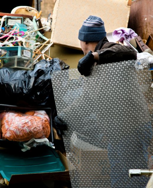 A man next to a heap of junk, illustrating a junk removal service based in Houston, Texas.