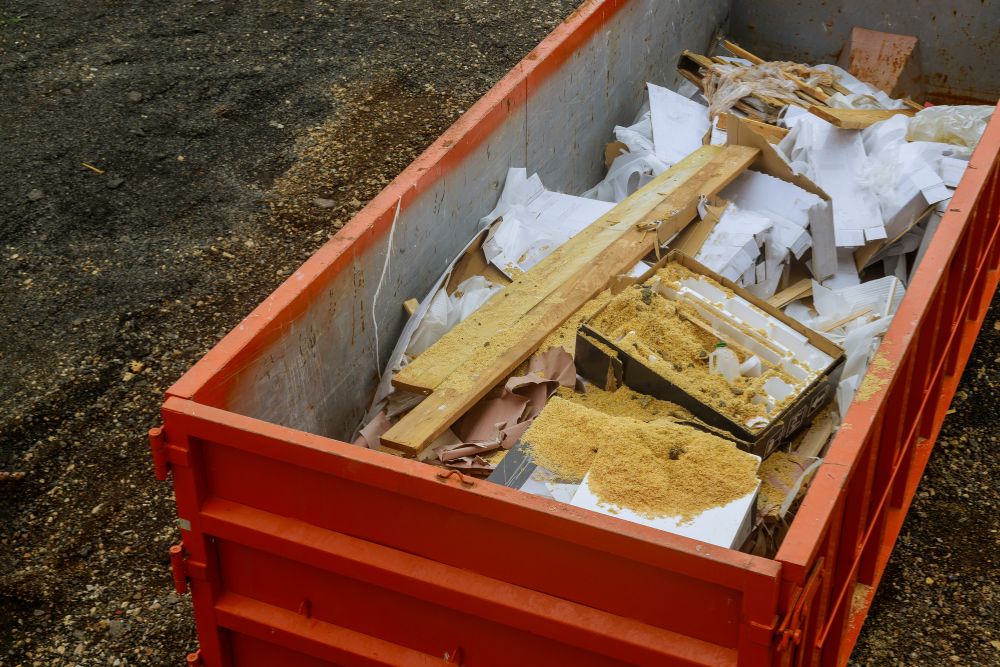 A dumpster brimming with wood and miscellaneous materials, illustrating a specialized junk removal service in Houston, TX.